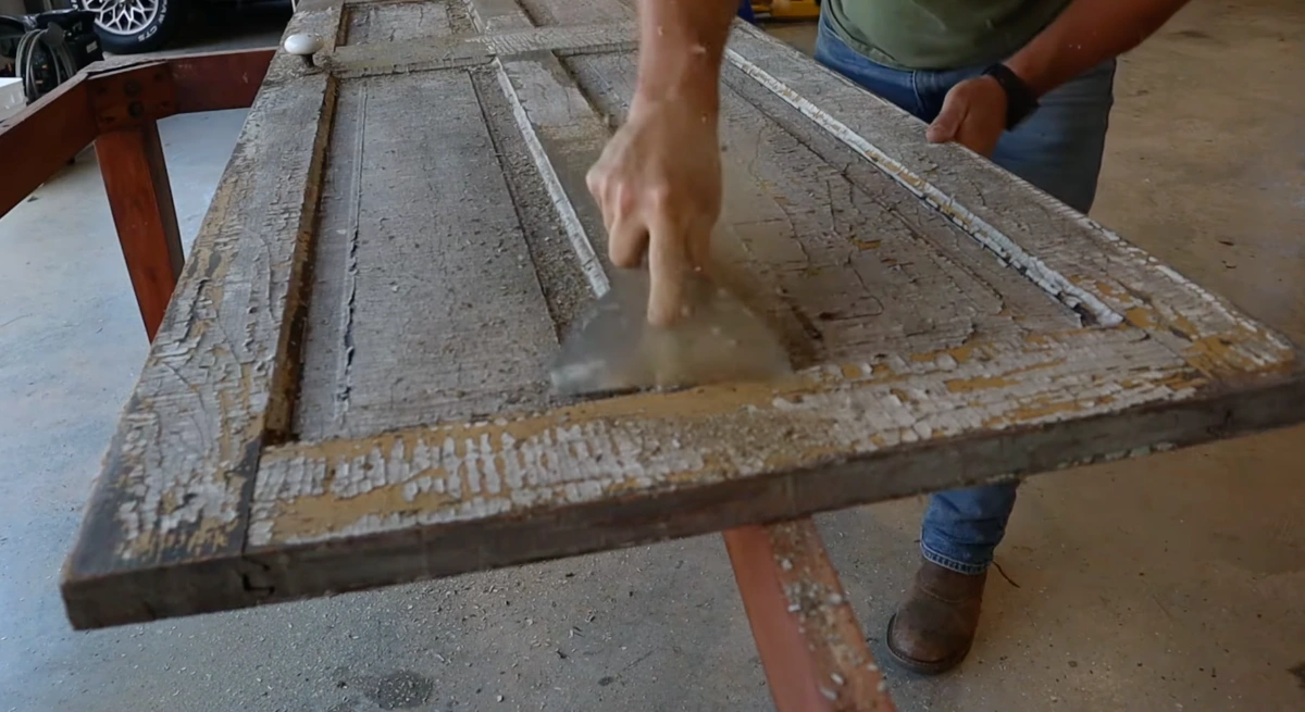 Antique door hardware and brass fixtures being restored on workshop table